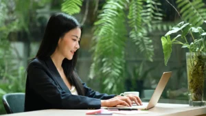 smiling-millennial-businesswoman-using-laptop-computer