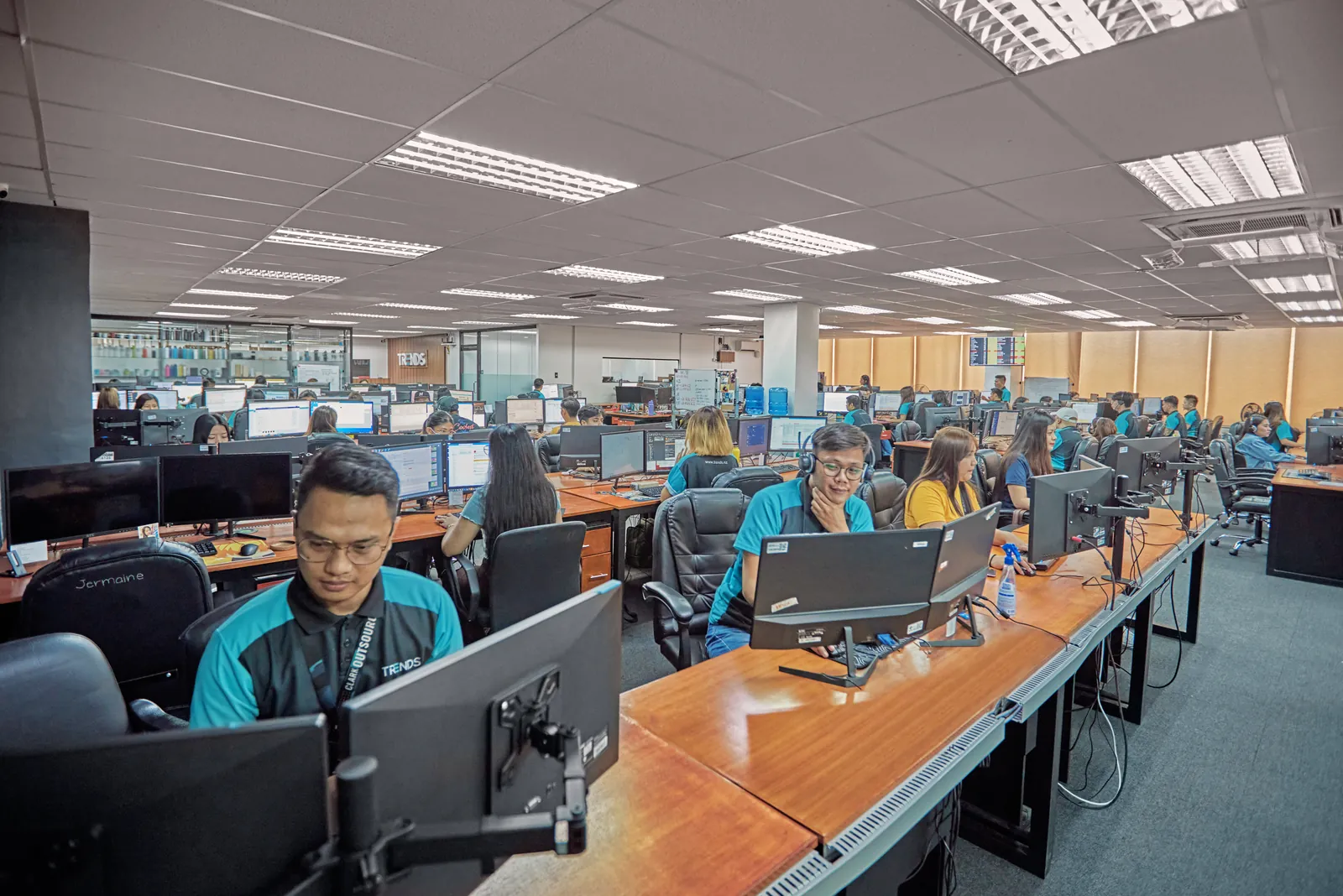 Team members working at rows of desktop computers in the Philippines outsourcing office