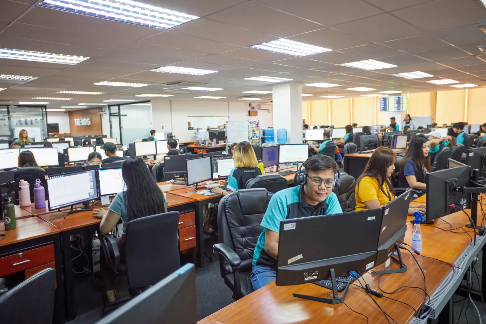 Staff member wearing a headset at a computer workstation in our Philippines office