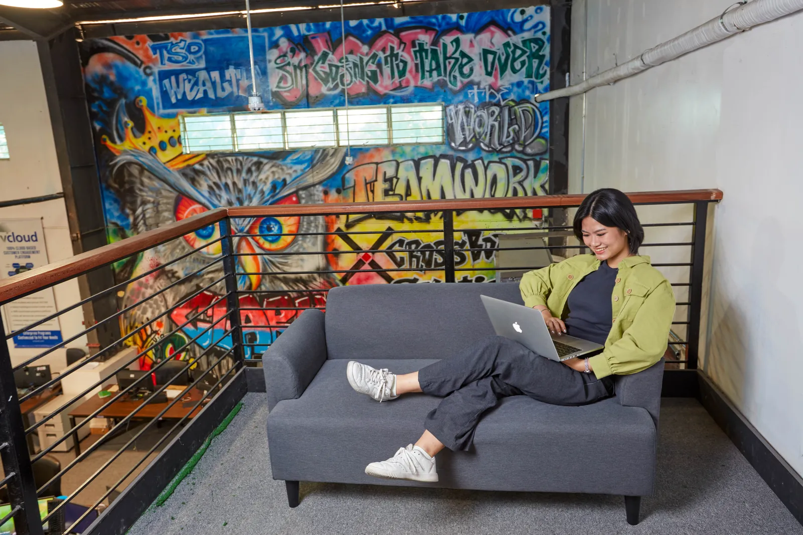 Staff member working on a laptop in a quiet seating area at the Philippines office